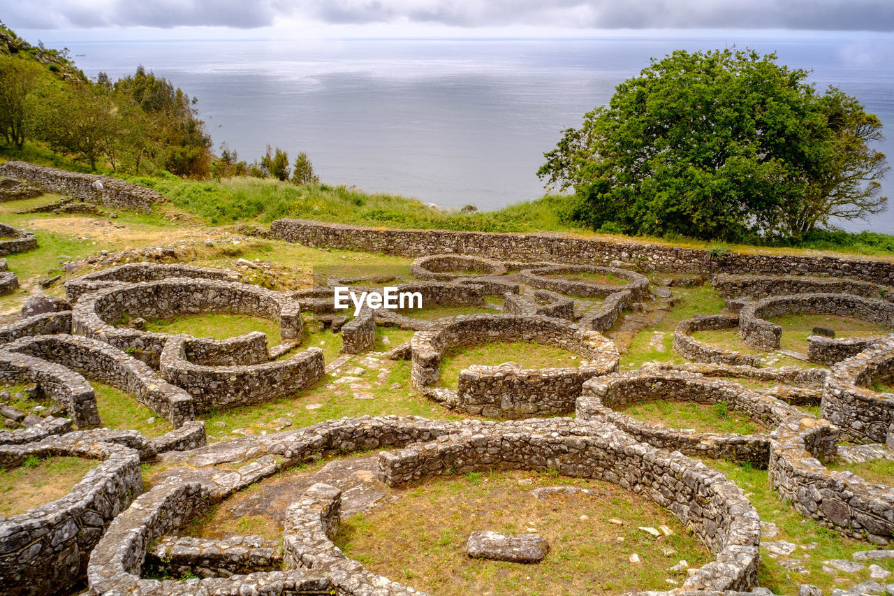 Scenic view of neolithic village against cloudy sky