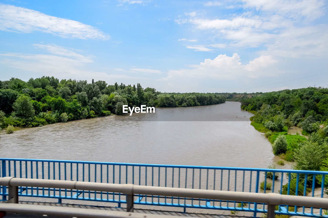 RIVER AMIDST TREES AGAINST SKY