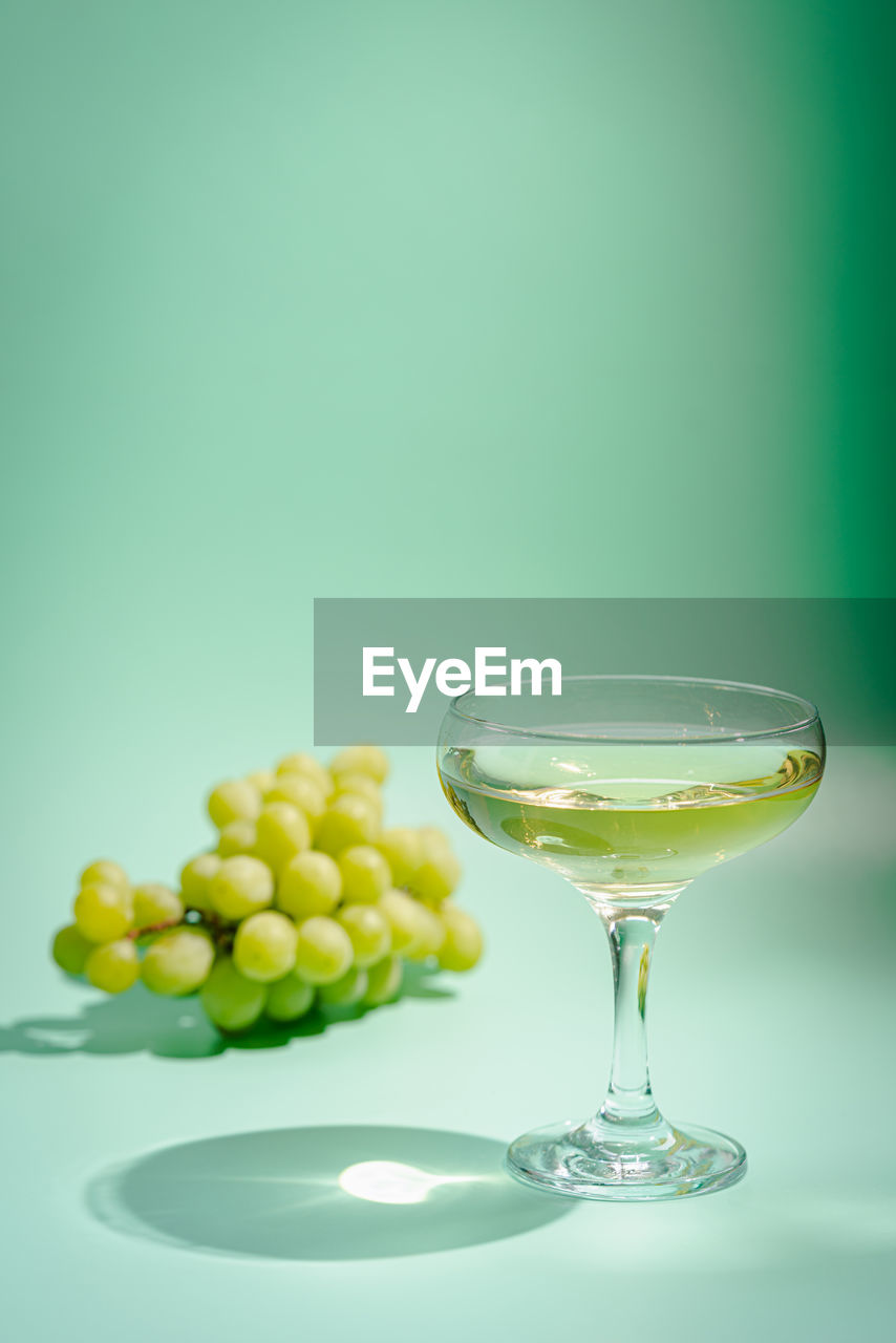 Grapes and wine against green background