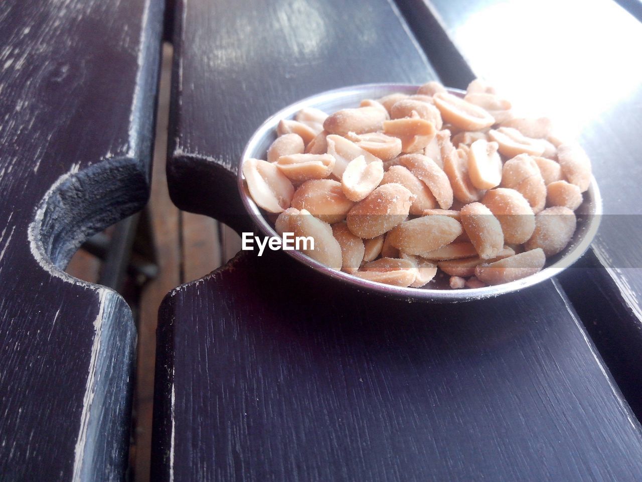 High angle view of salted peanuts in bowl on table