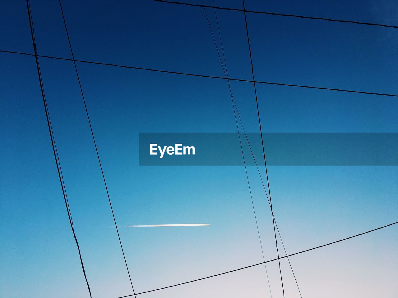 LOW ANGLE VIEW OF ELECTRICITY PYLON AGAINST BLUE SKY