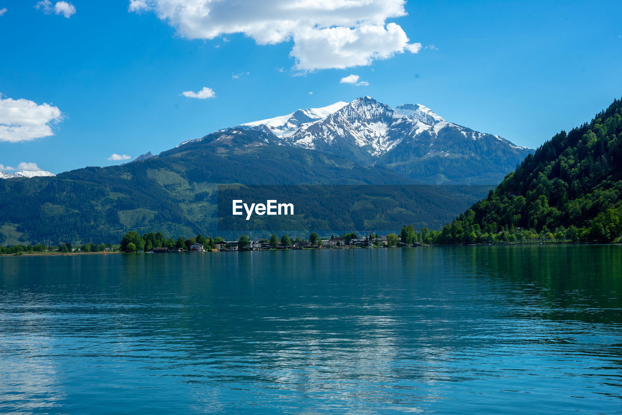 Scenic view of lake and mountains against blue sky