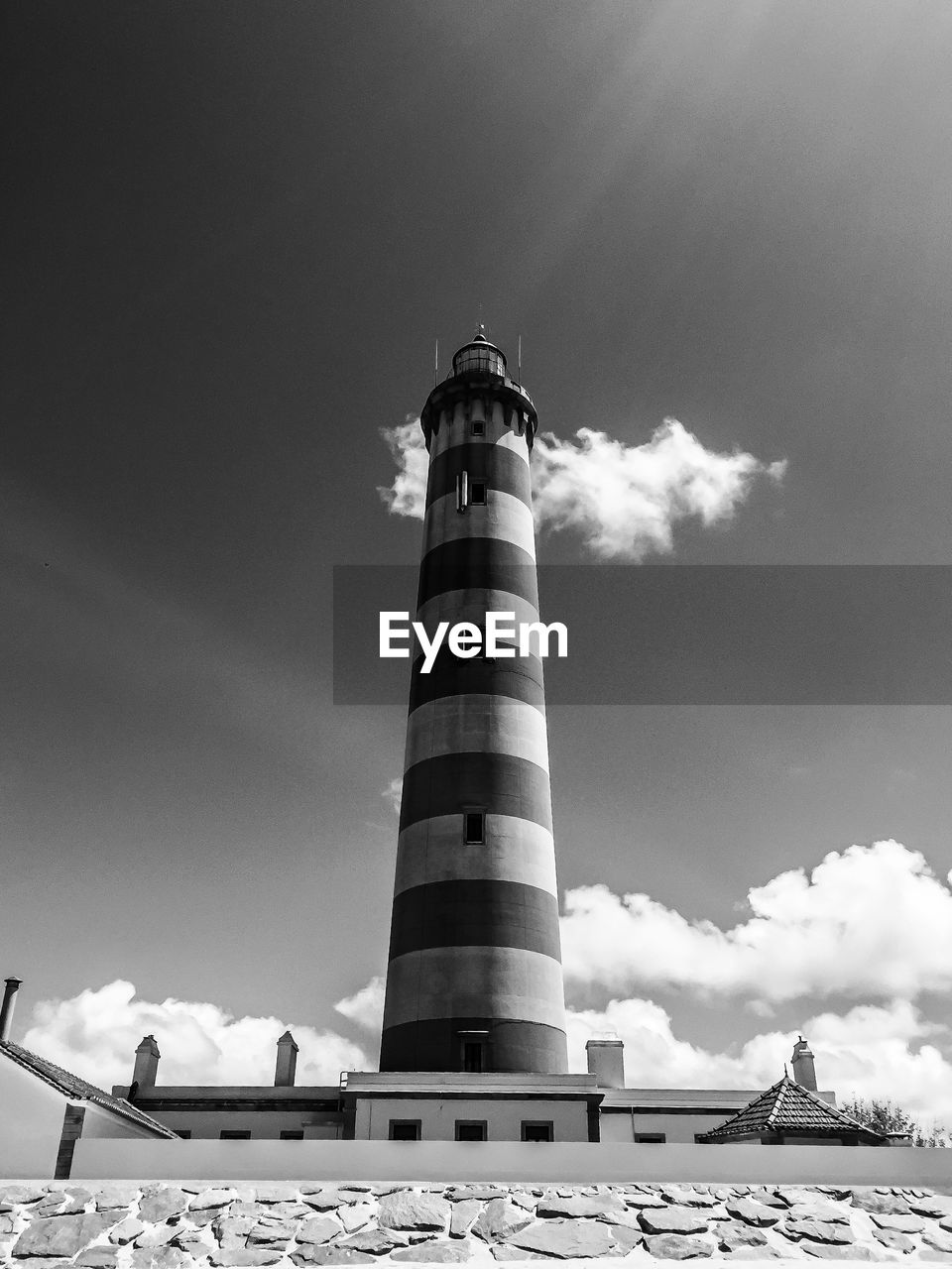 LOW ANGLE VIEW OF LIGHTHOUSE AGAINST BUILDING AND SKY