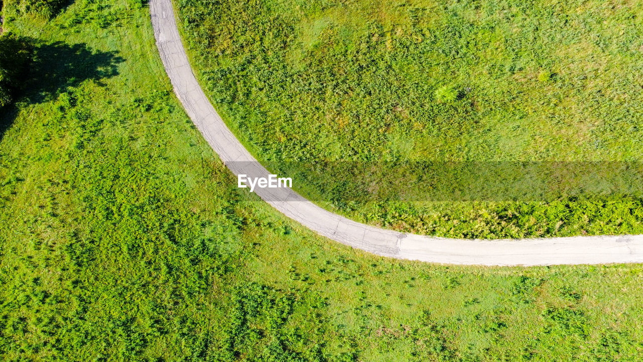 Aerial view of a countryside road between meadows and trees in emilia romagna region, italy