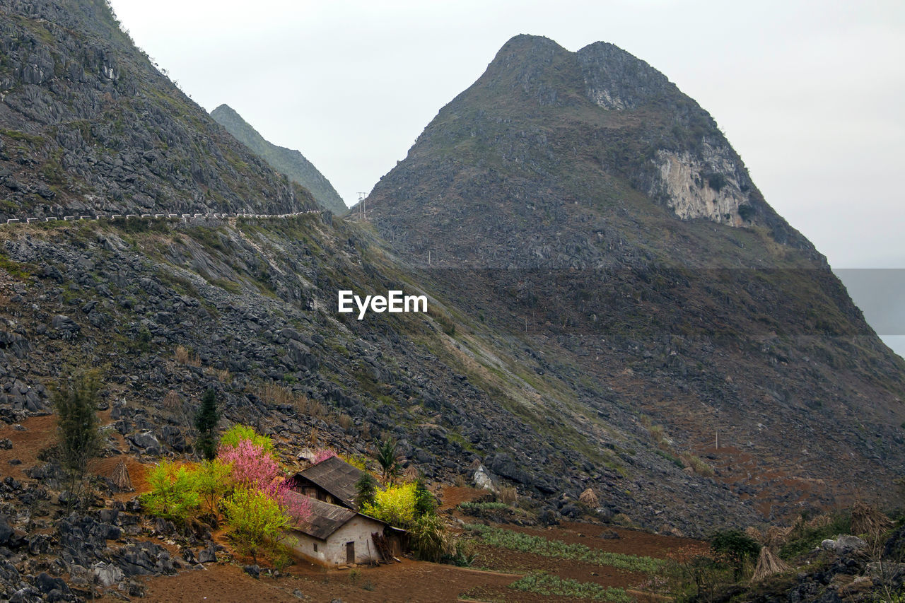 SCENIC VIEW OF MOUNTAIN AND HOUSES AGAINST SKY