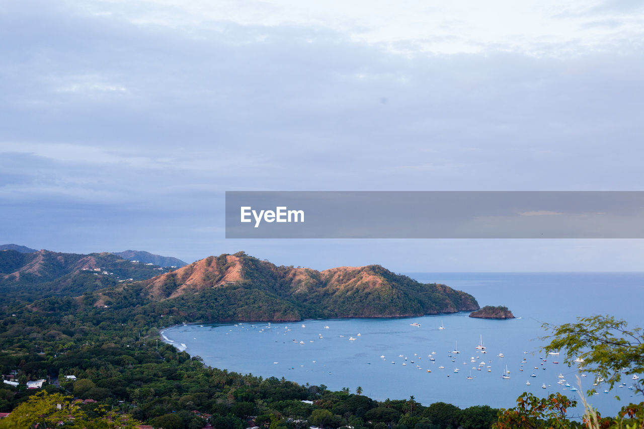 Scenic view of sea and mountains against sky