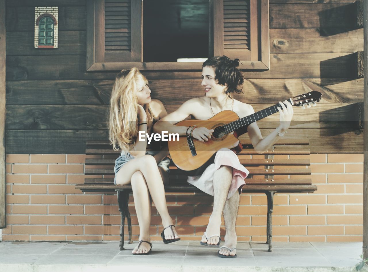 Boy playing guitar with girl