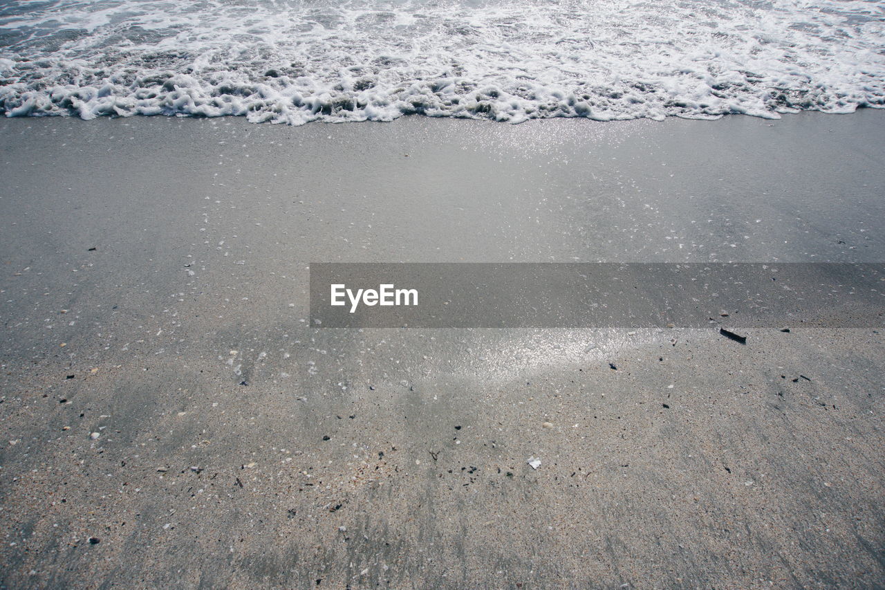 High angle view of waves rushing towards shore at beach