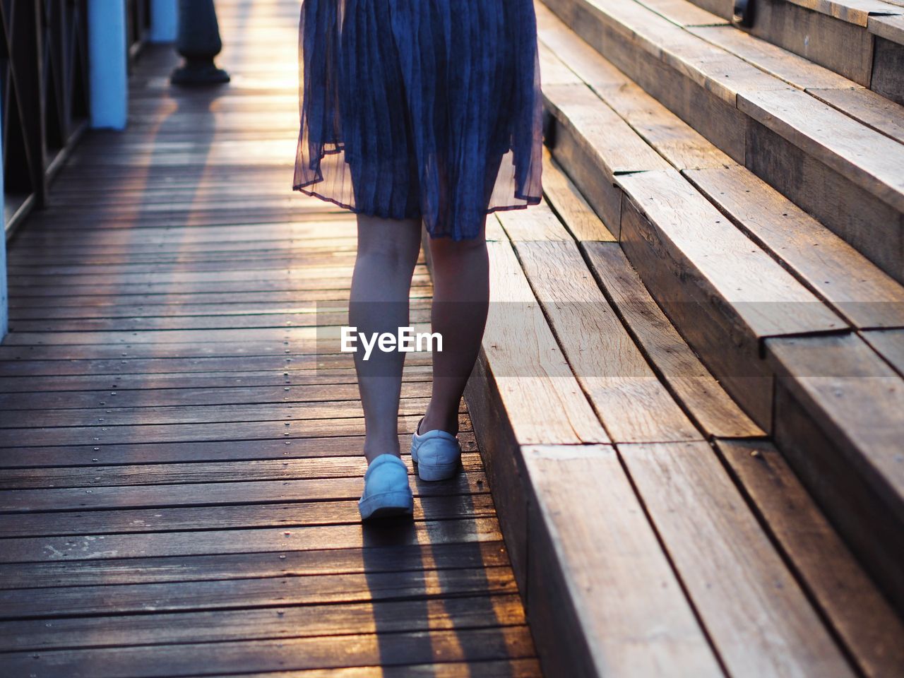 Low section of woman walking on hardwood floor