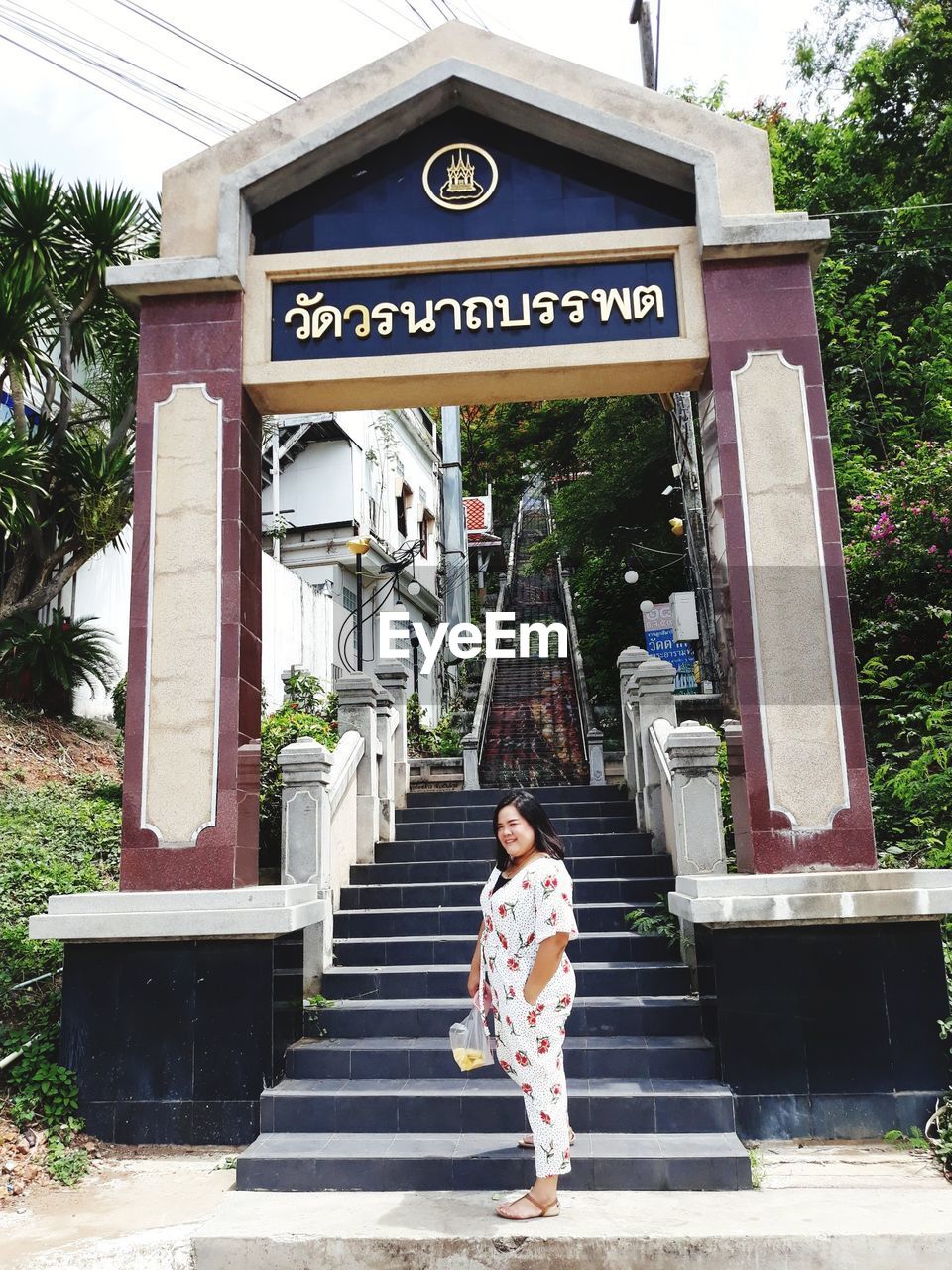 Smiling mid adult woman standing against entrance gate