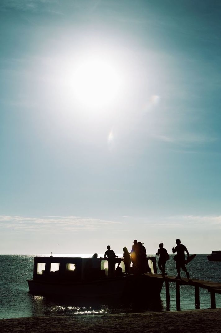 Silhouette people overlooking calm sea