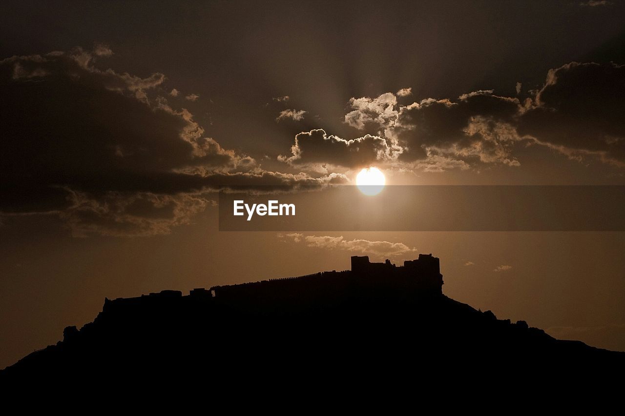 Low angle view of silhouette castle against sky during sunset