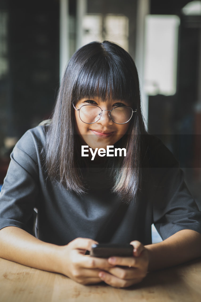 Portrait of smiling girl using mobile phone