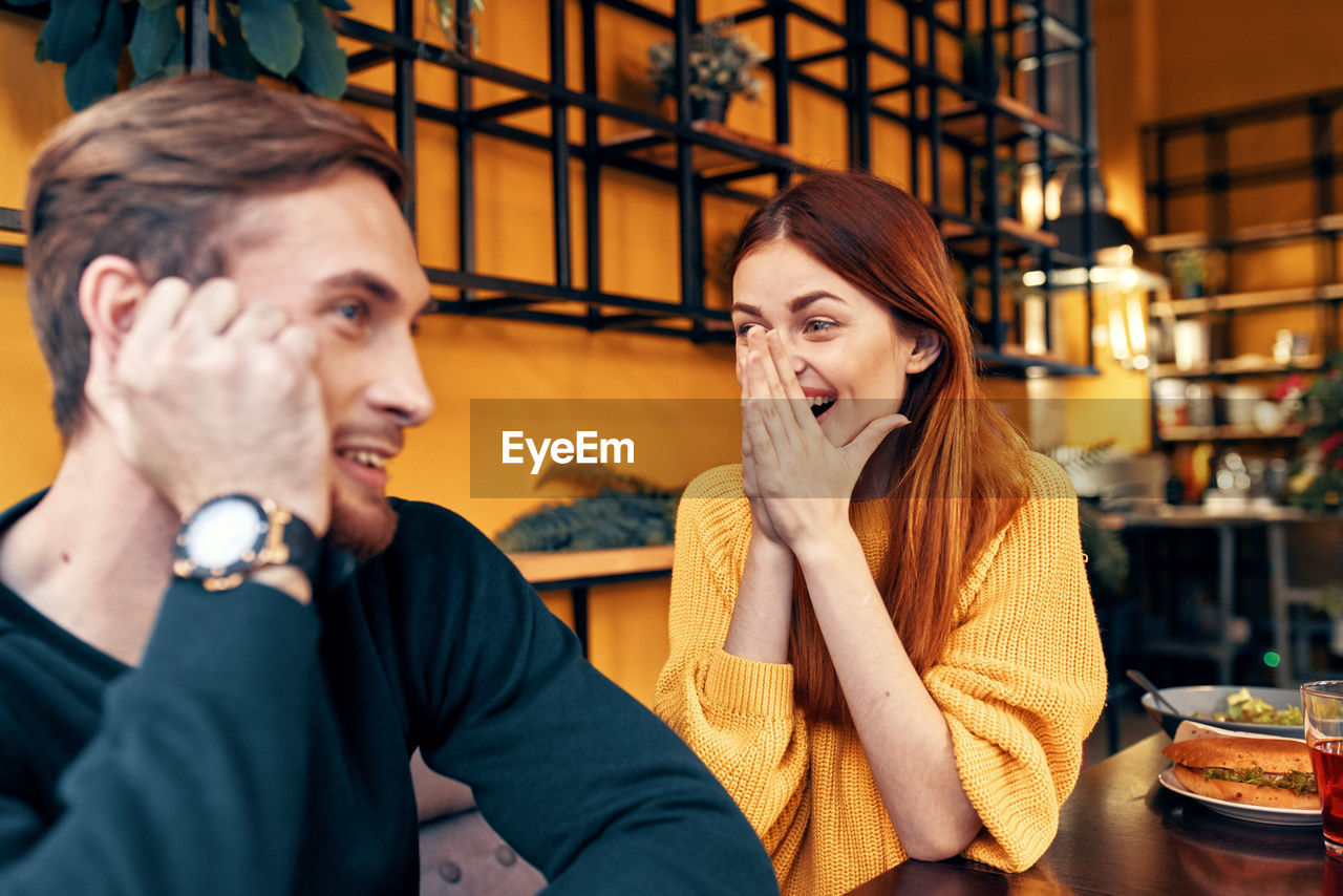 Portrait of young couple sitting in restaurant