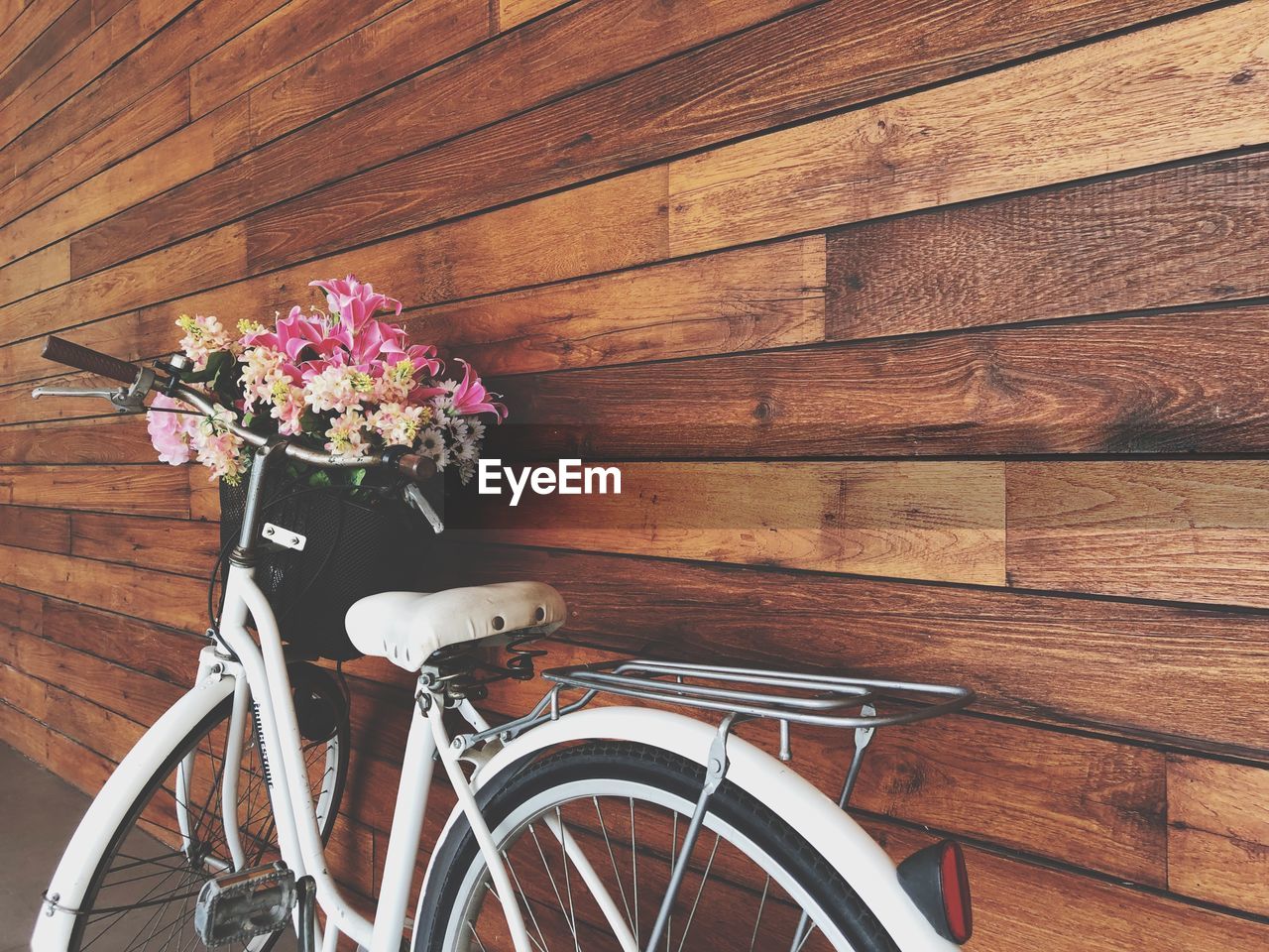 Close-up of bicycle leaning on wooden wall