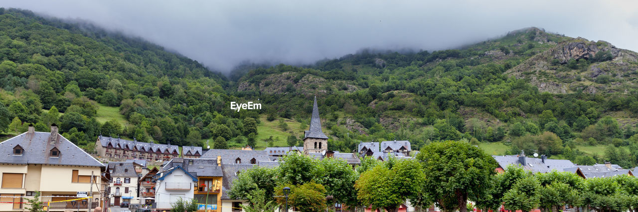 Scenic view of trees and buildings against sky