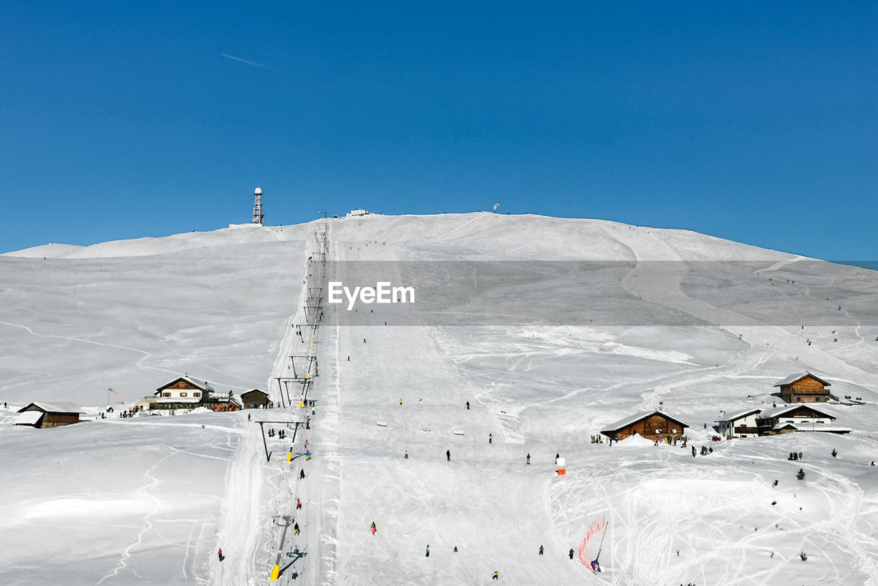 Skiing fun on corno del renon in the southtyrolean alps with view to the mountain huts in winter 