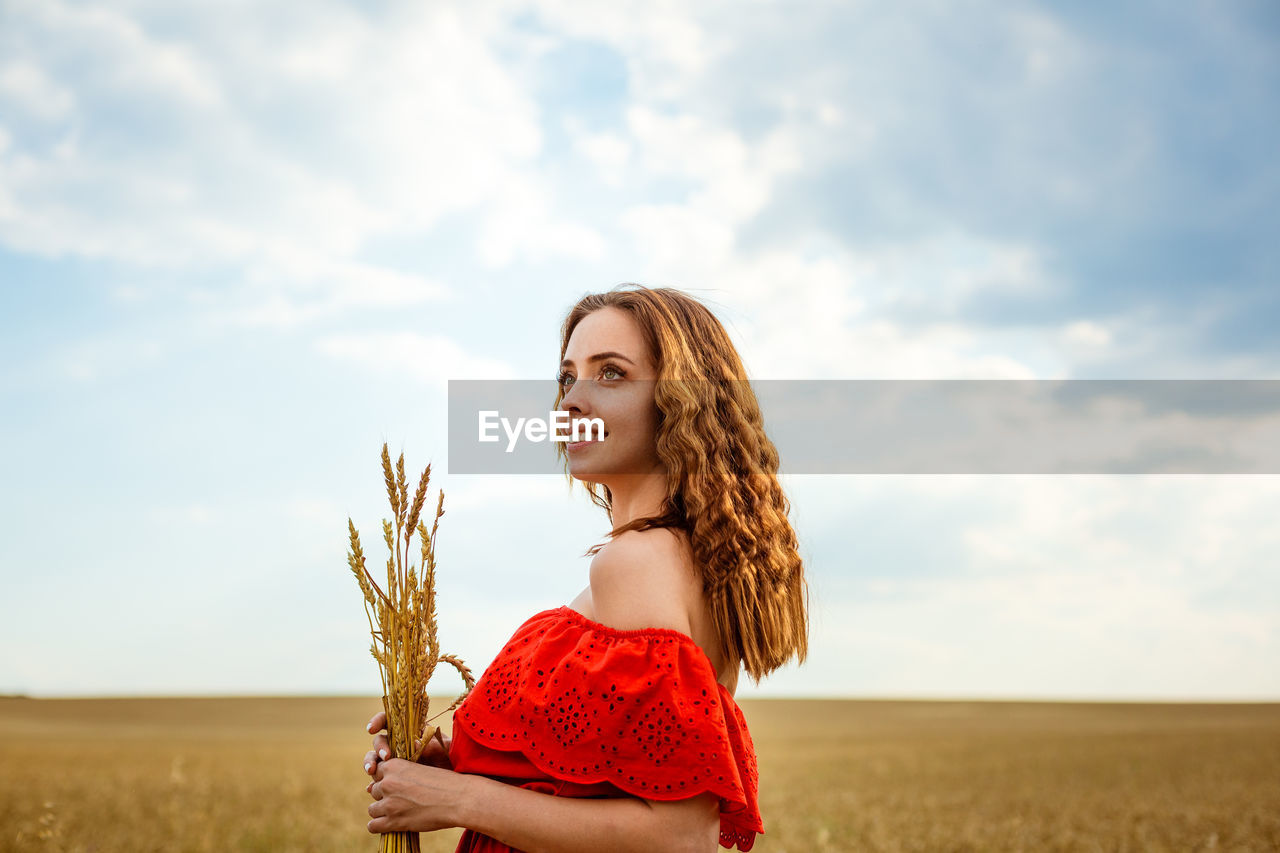 Young beautiful woman in golden wheat field. happy woman