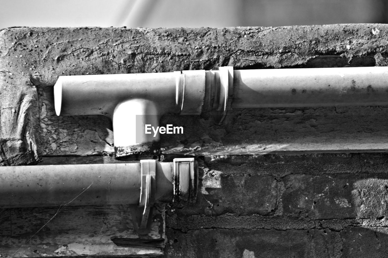 CLOSE-UP OF PIPE AGAINST WALL