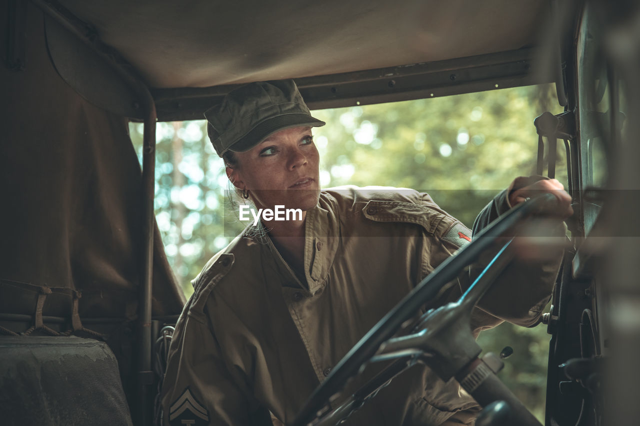 Woman soldier holding steering wheel of car