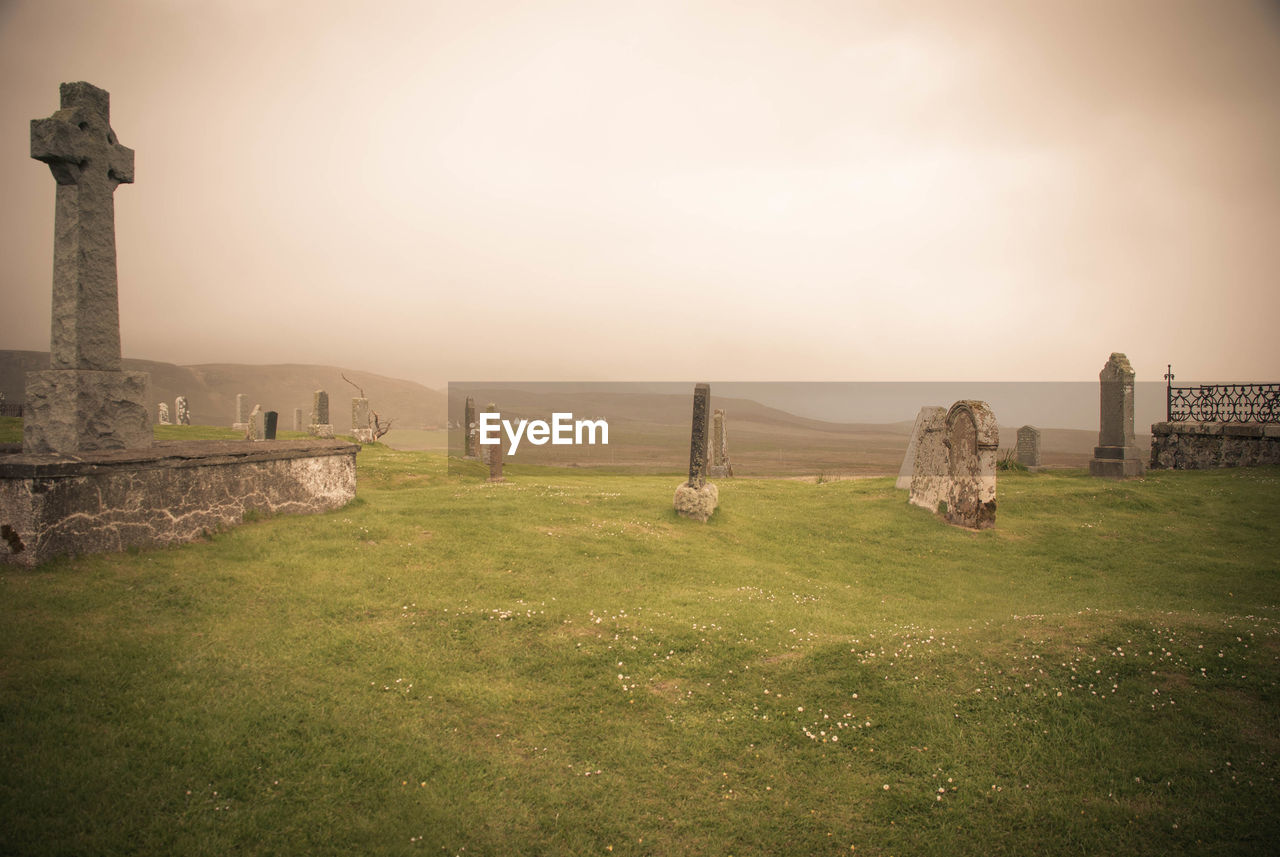 Tranquil scene of cemetery against sky during foggy weather