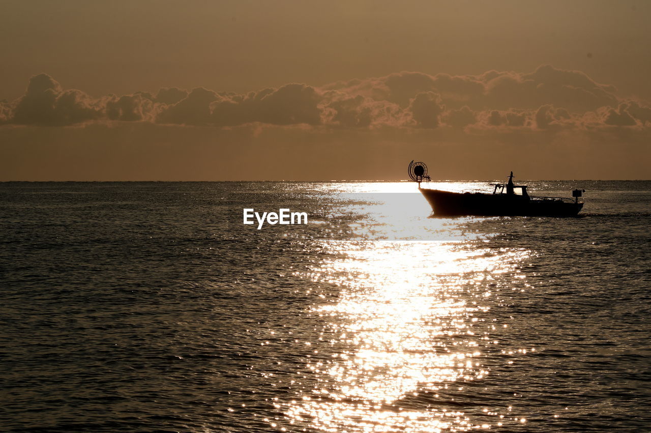 SILHOUETTE NAUTICAL VESSEL ON SEA AGAINST SKY DURING SUNSET