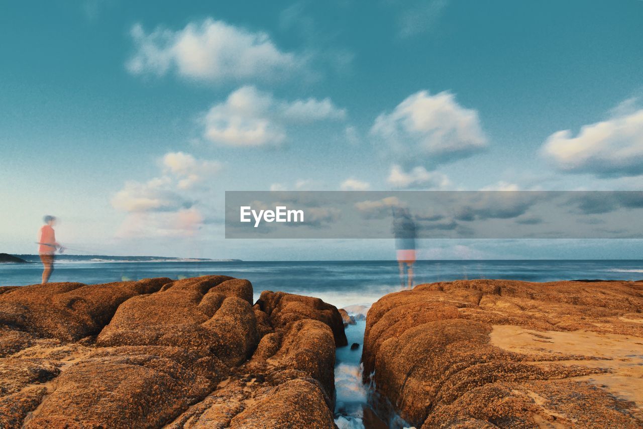 ROCKS ON BEACH AGAINST SKY