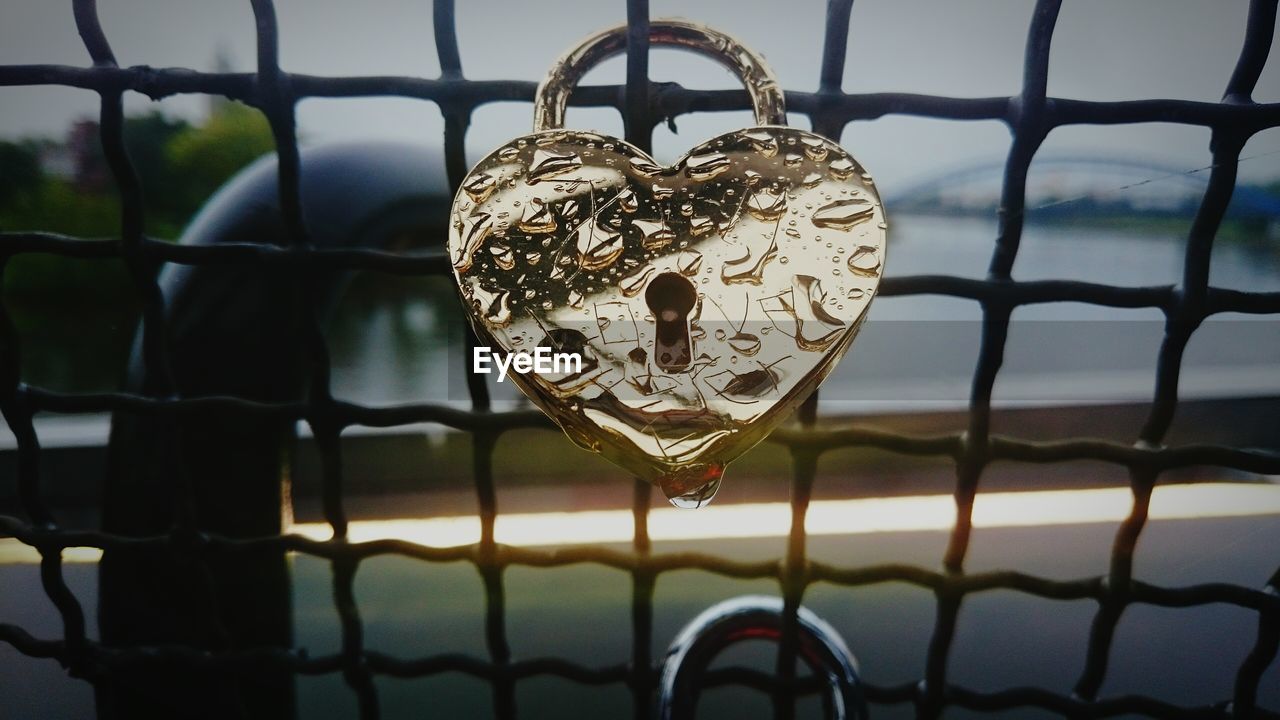 Close-up of love lock on metal grate