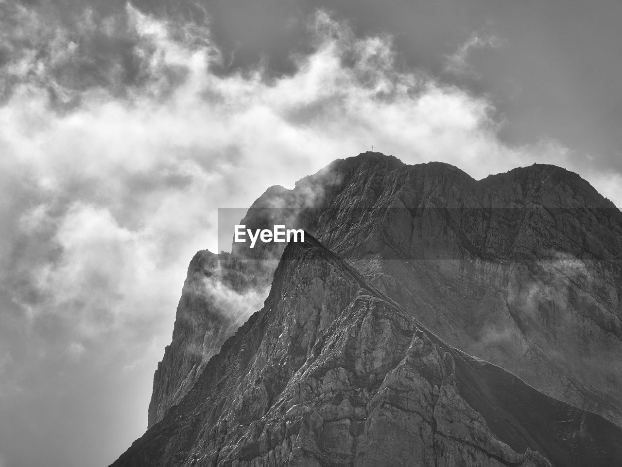 mountain, cloud, black and white, sky, rock, beauty in nature, scenics - nature, environment, landscape, monochrome, monochrome photography, mountain range, nature, land, mountain peak, travel destinations, no people, geology, non-urban scene, travel, outdoors, tranquility, rock formation, darkness, extreme terrain, day, physical geography, tranquil scene