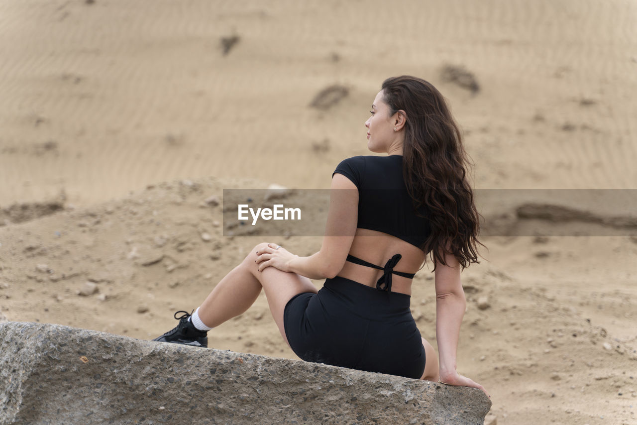 Full length of woman exercising on land against sky