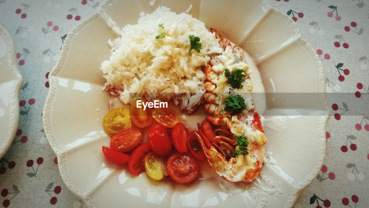 Directly above shot of rice with tomato and lobster on plate