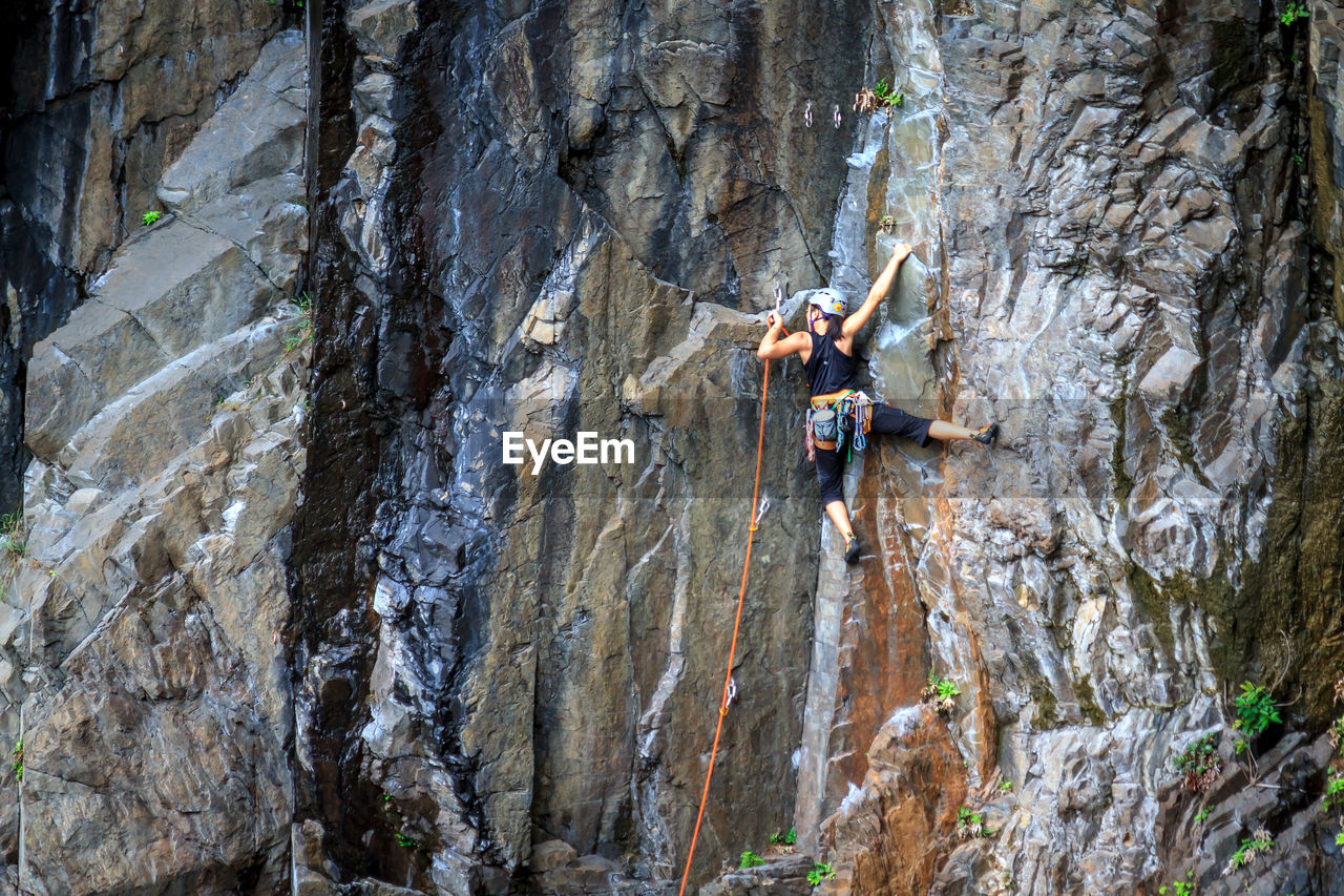 Young woman climbing on rock