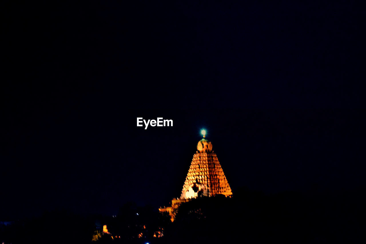 LOW ANGLE VIEW OF ILLUMINATED BUILDING AT NIGHT