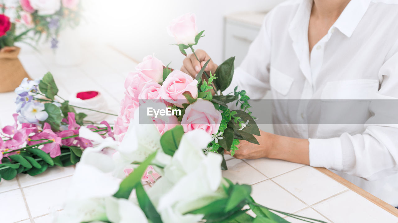 Midsection of florist making bouquet on table
