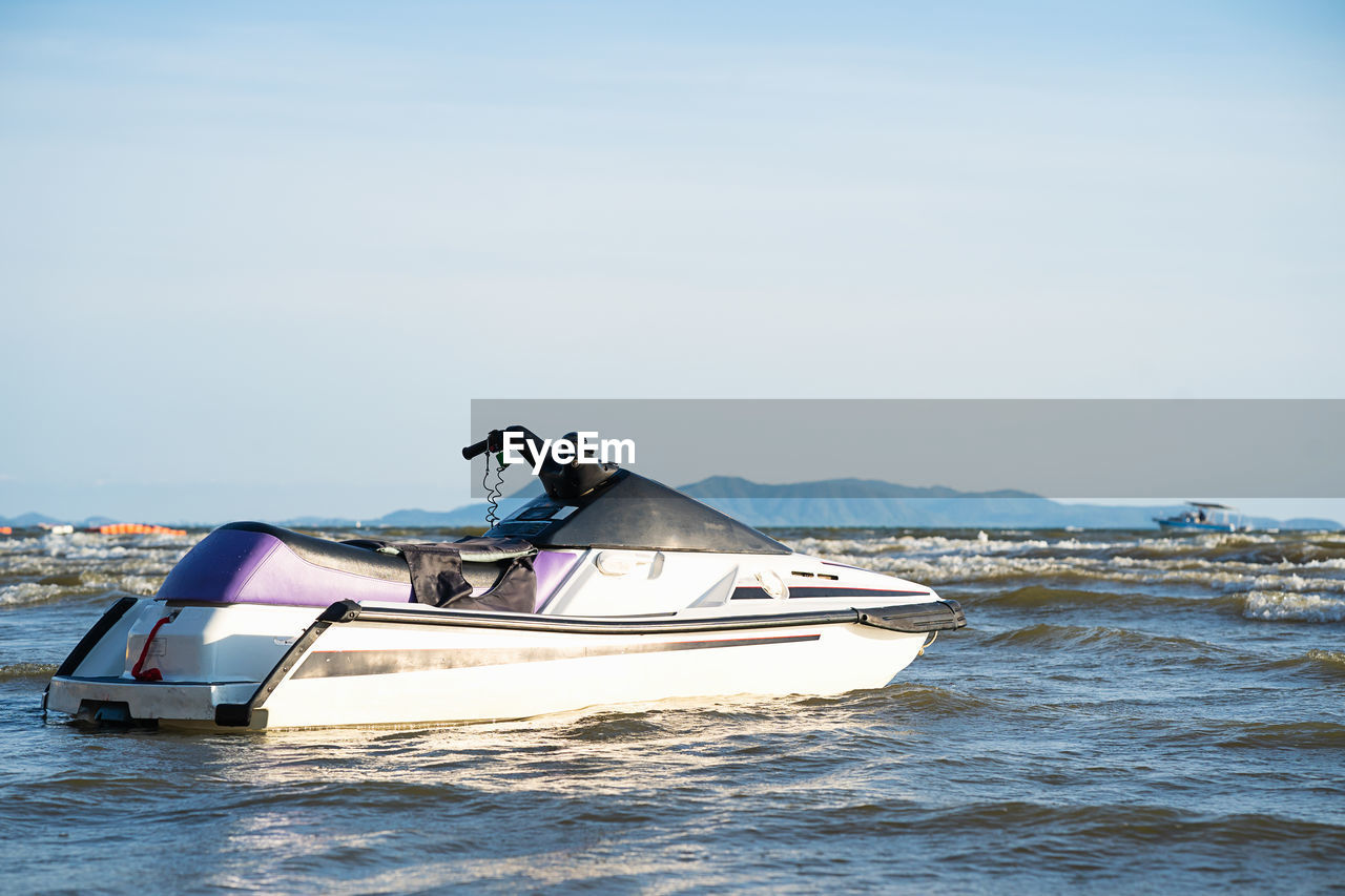 Man on boat in sea against sky