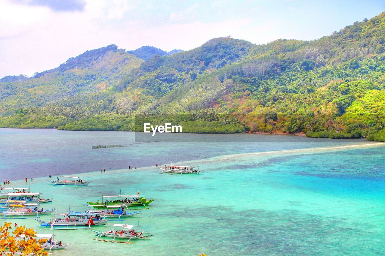 High angle view of sea and mountains against sky