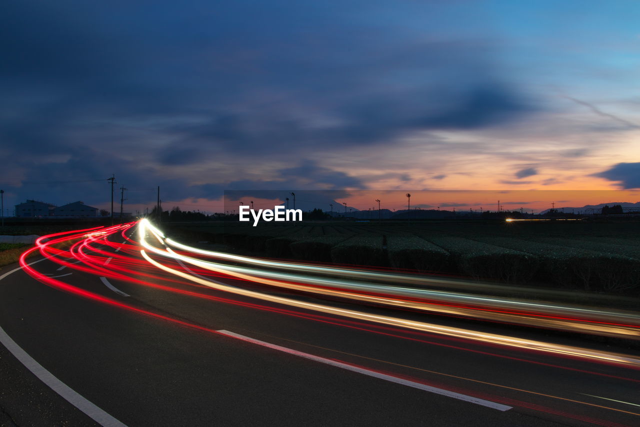 Light trails on road against sky at night