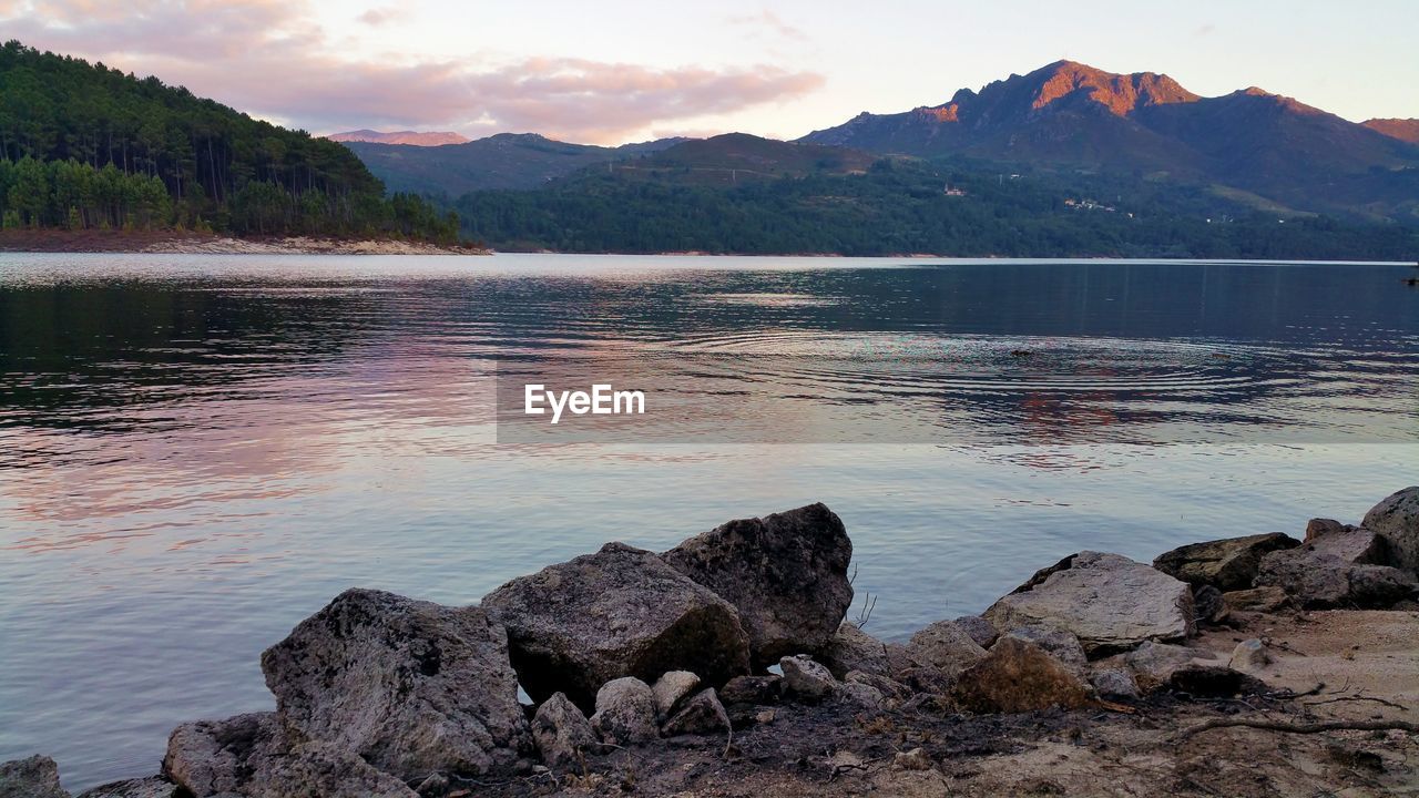 Scenic view of lake by mountains against sky