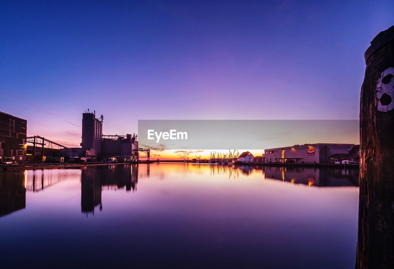 REFLECTION OF ILLUMINATED BUILDINGS IN CITY AGAINST SKY