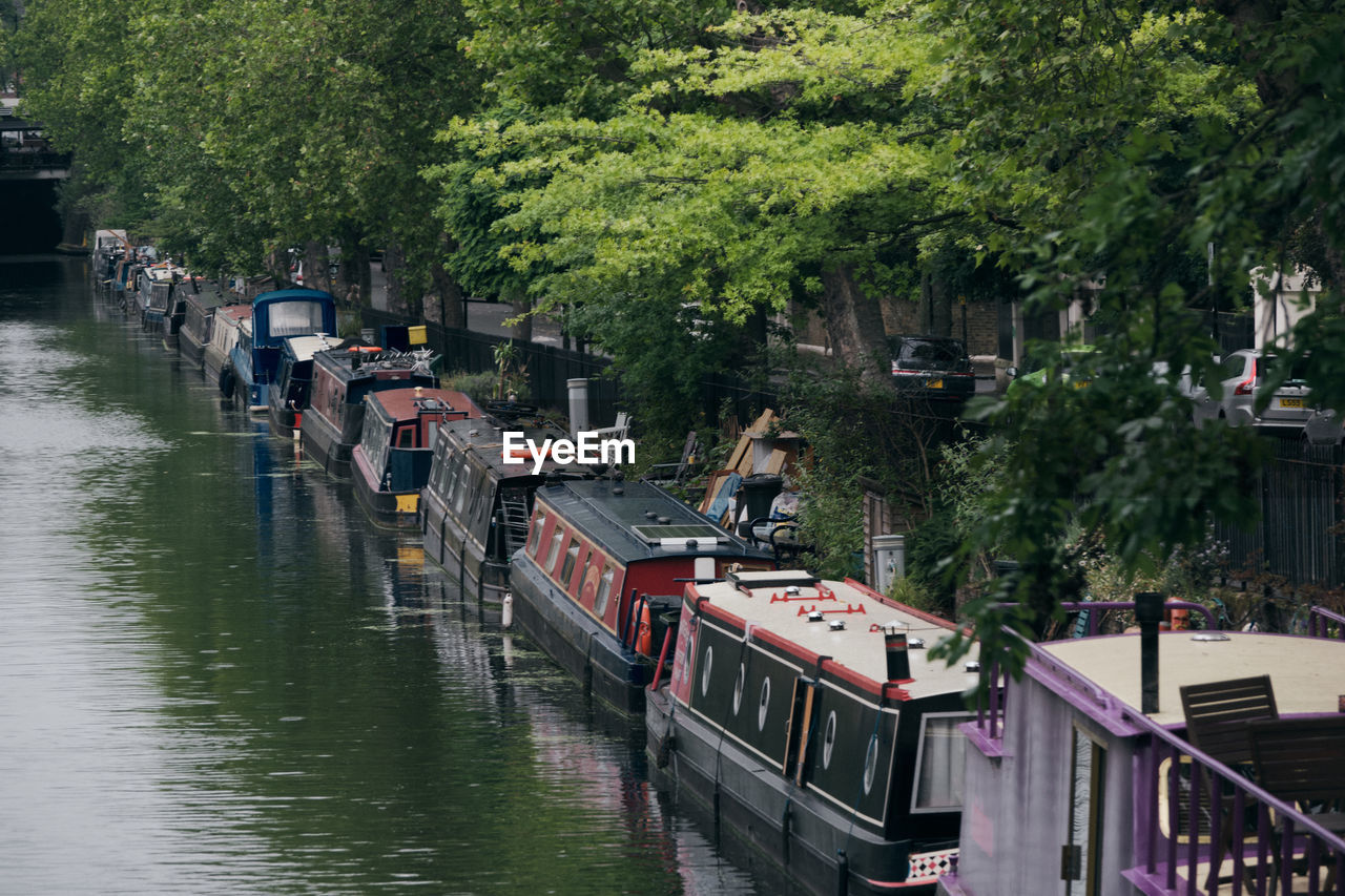 PANORAMIC VIEW OF BOATS MOORED IN RIVER BY TREES