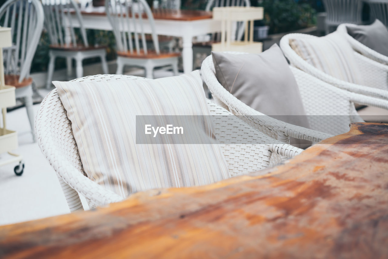 Close-up of white chairs by table at restaurant