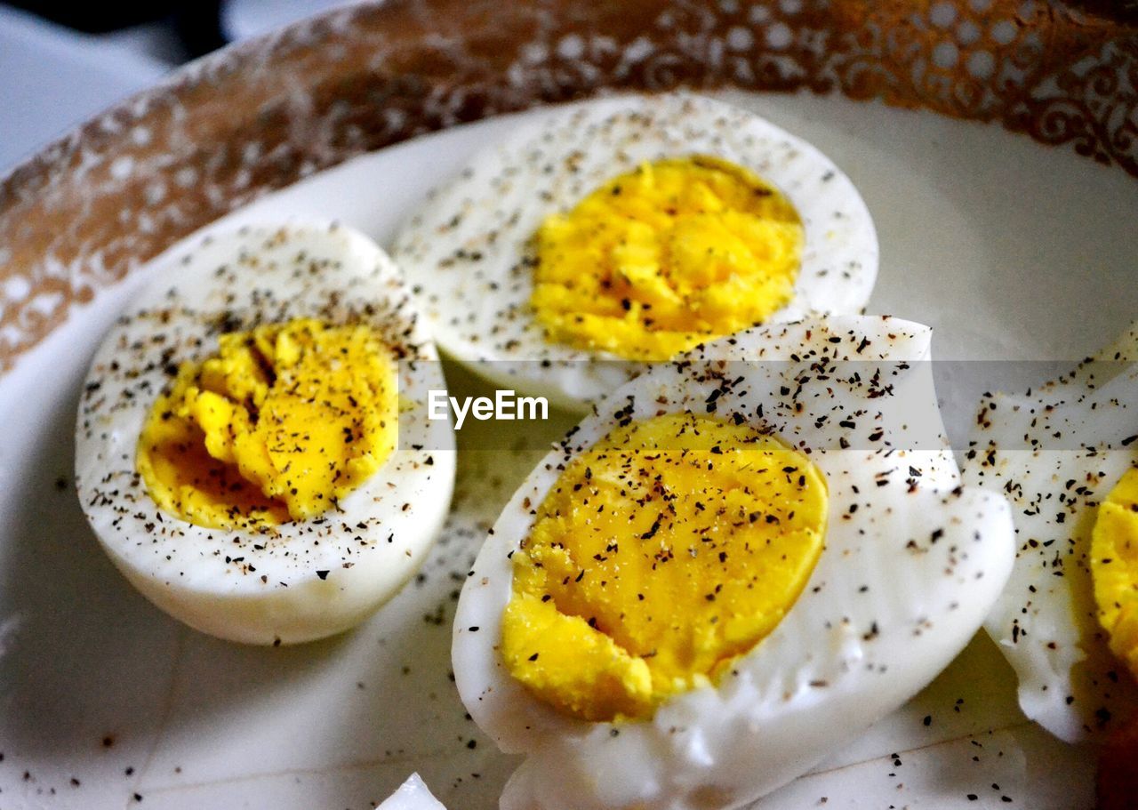 High angle view of pepper on boiled eggs in plate