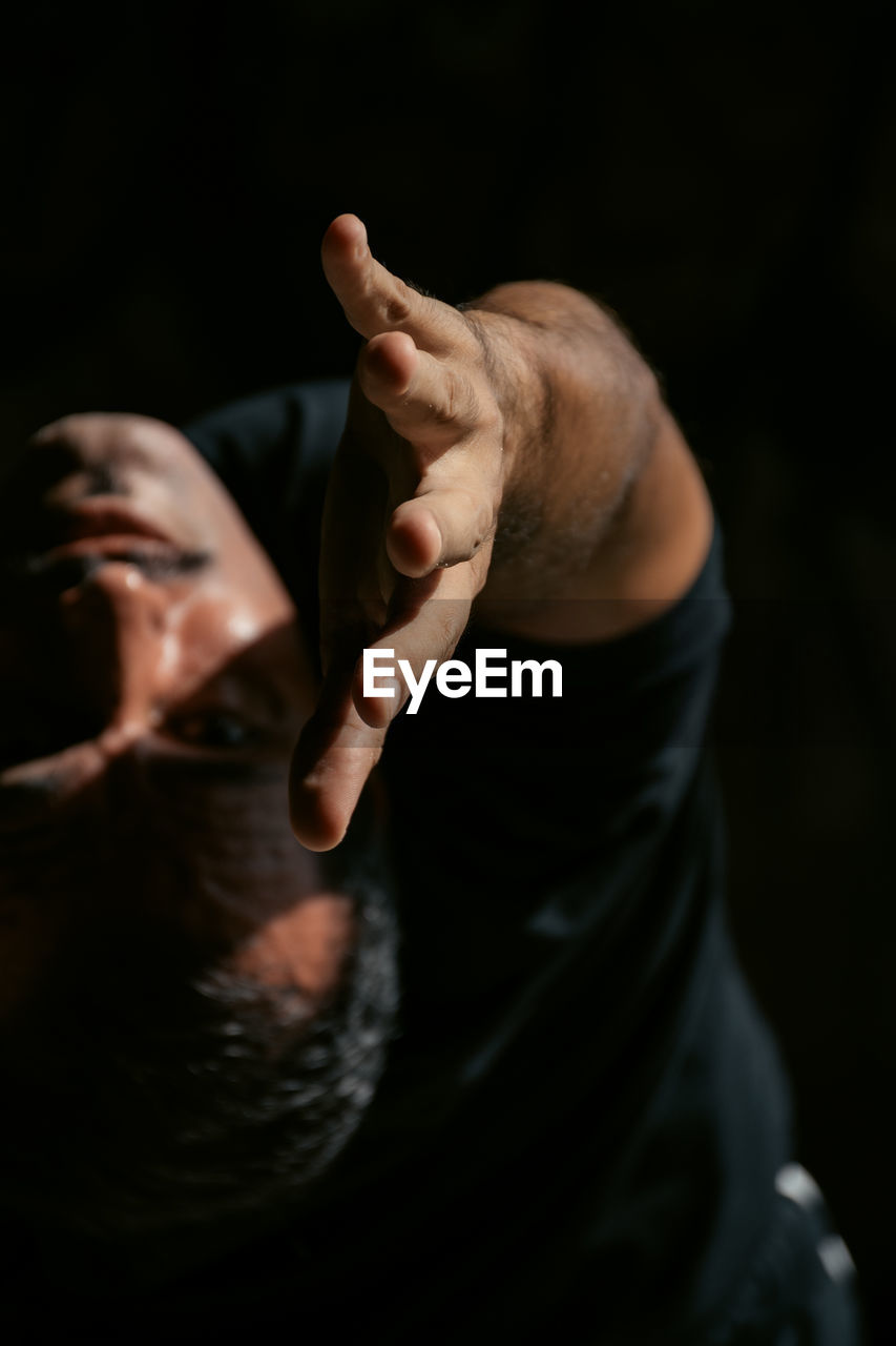 Midsection of yoga man against black background