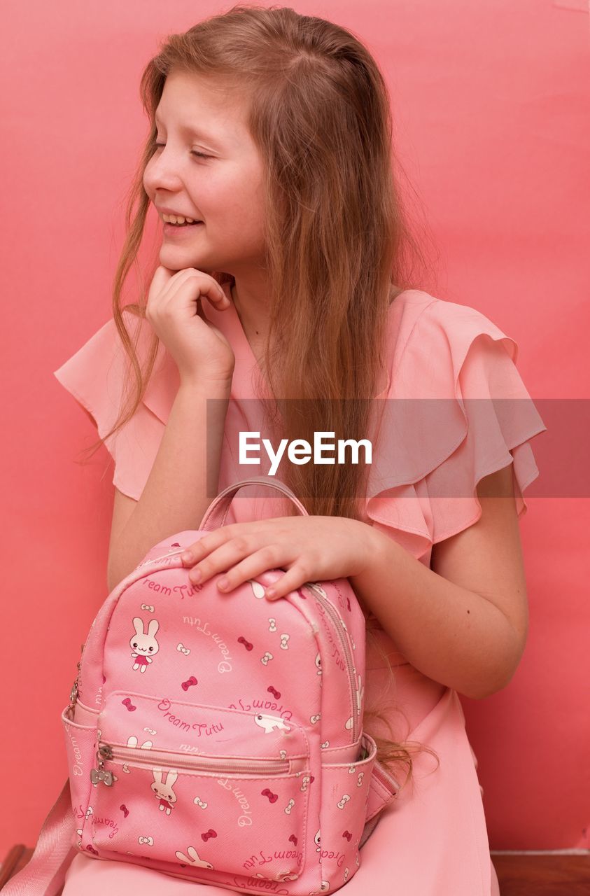 Teenage girl in a pink dress with a pink backpack