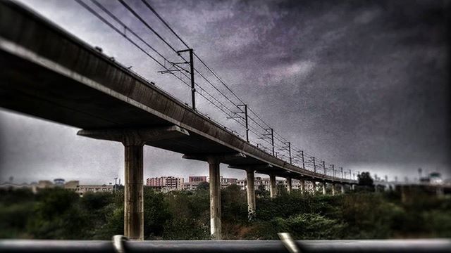 SUSPENSION BRIDGE AGAINST CLOUDY SKY