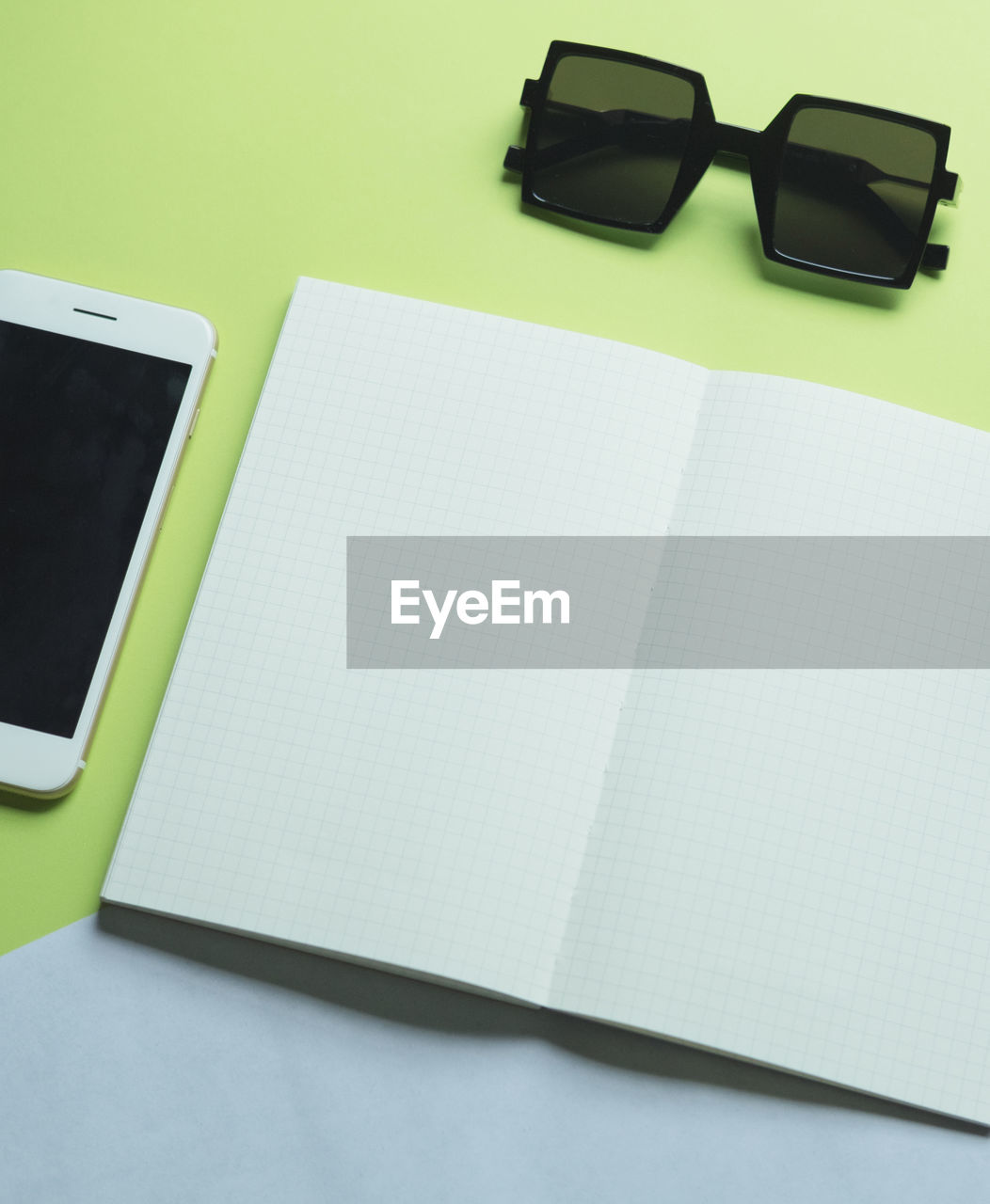 High angle view of blank book by sunglasses on table