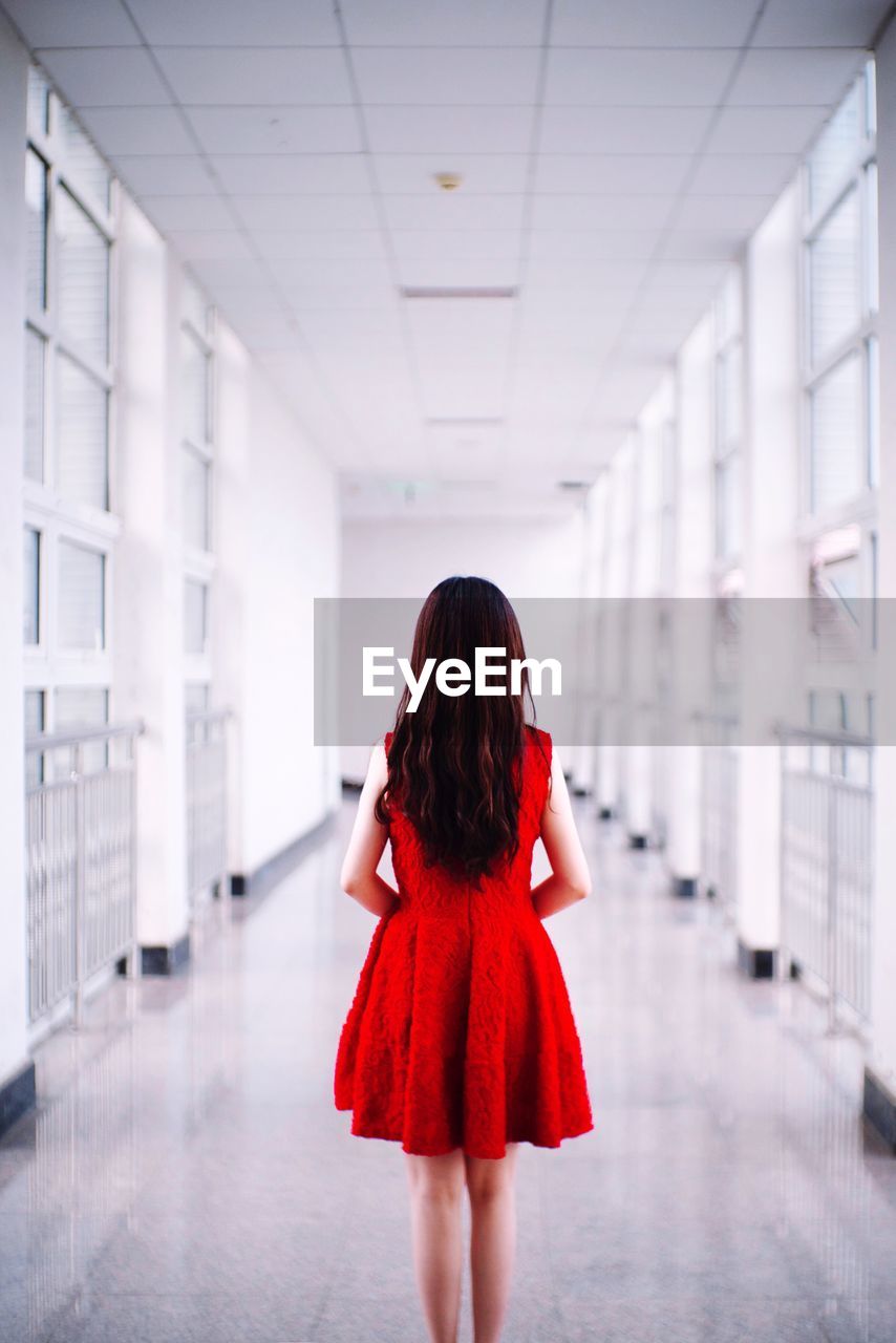 Rear view of young woman standing in corridor