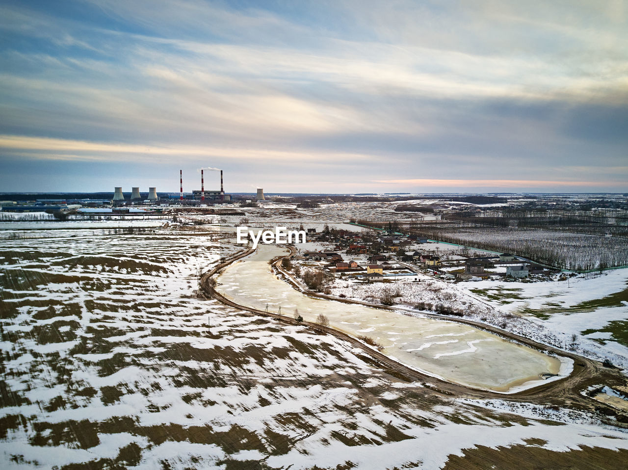 Aerial view power station in evening light. early spring urban industrial landscape. snow melting