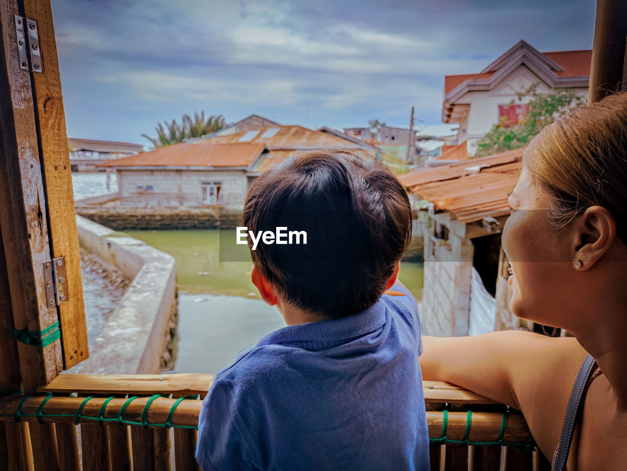 Rear view of woman and a child looking into the window.