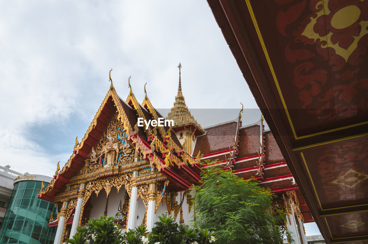 Low angle view of temple amidst buildings against sky